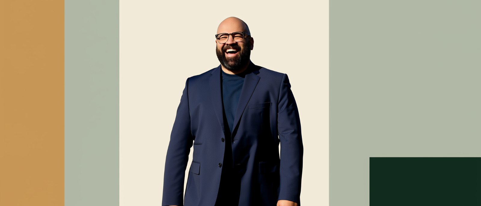 A laughing man in a suit wearing eyeglasses