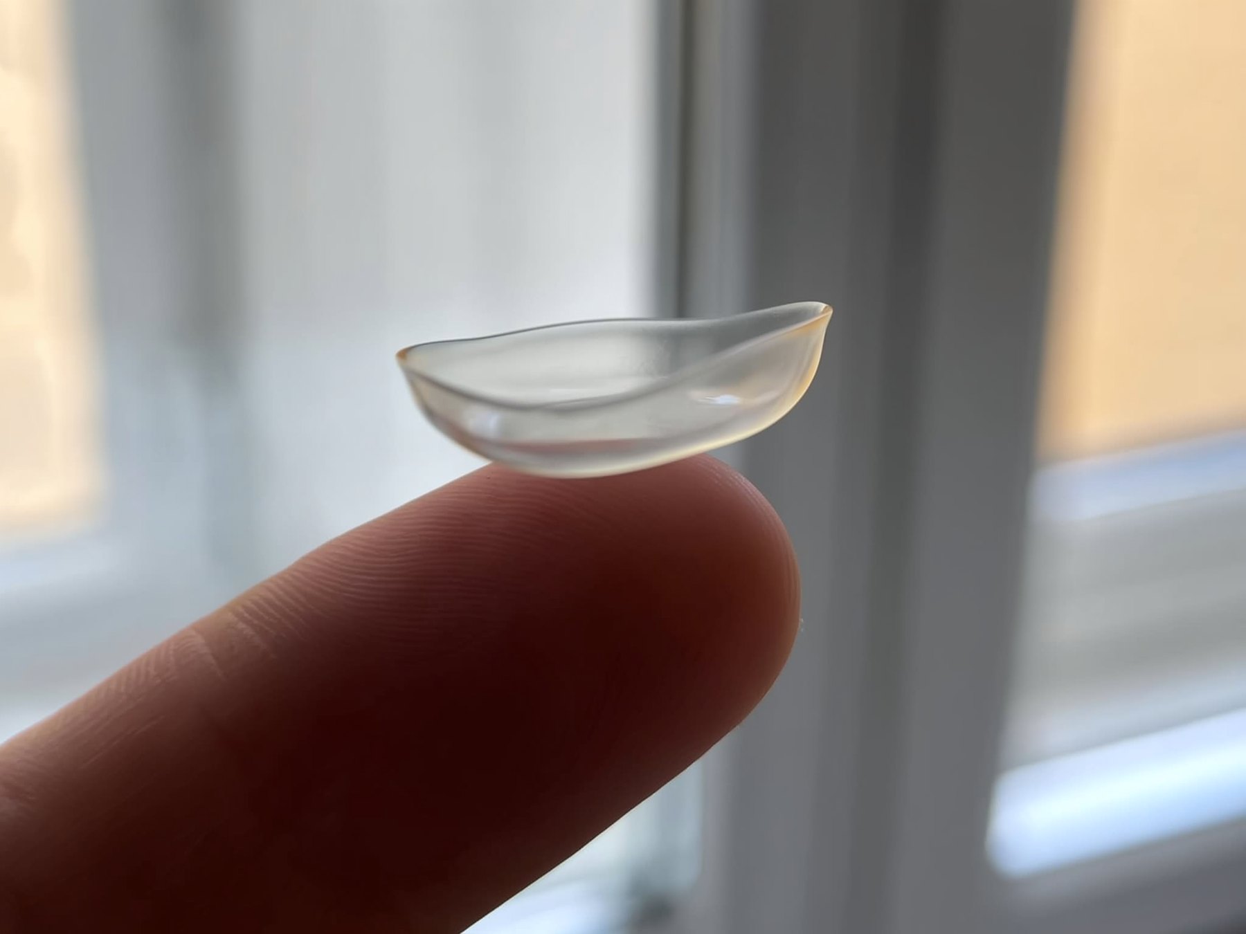 A soft contact lens on a fingertip